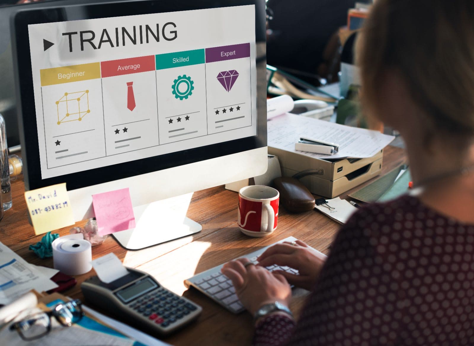Person at a desk viewing a training skill-levels screen on a monitor