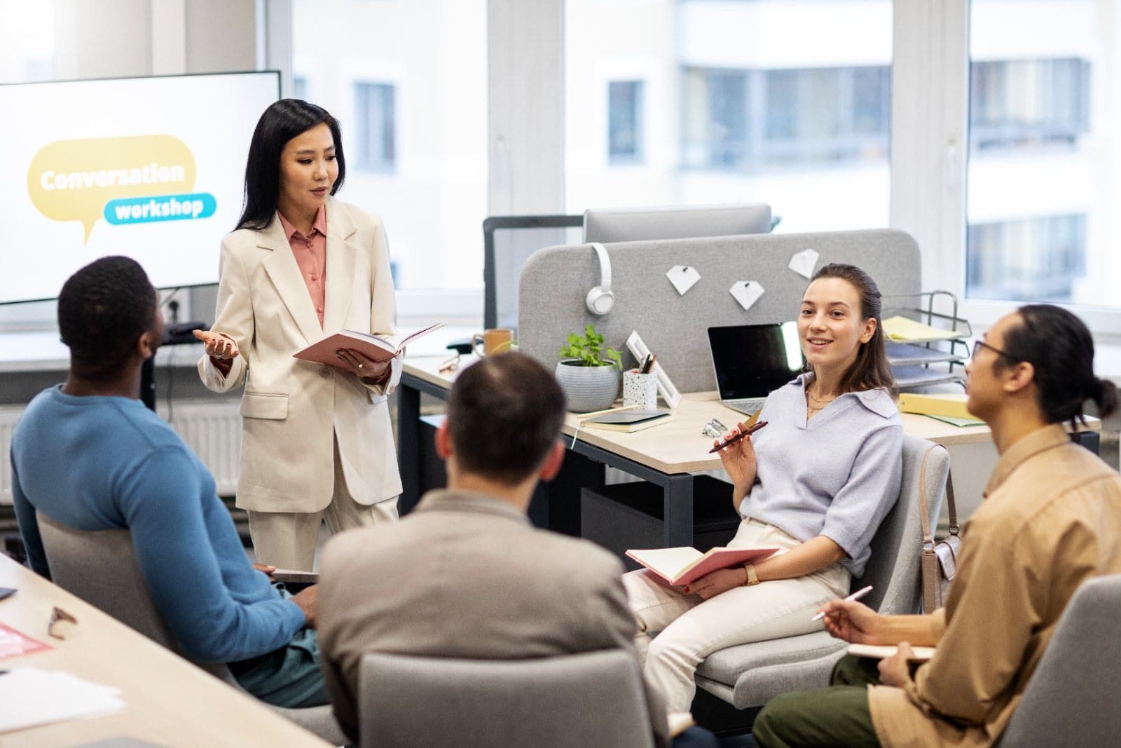Facilitator leading a conversation workshop with a small team in an office
