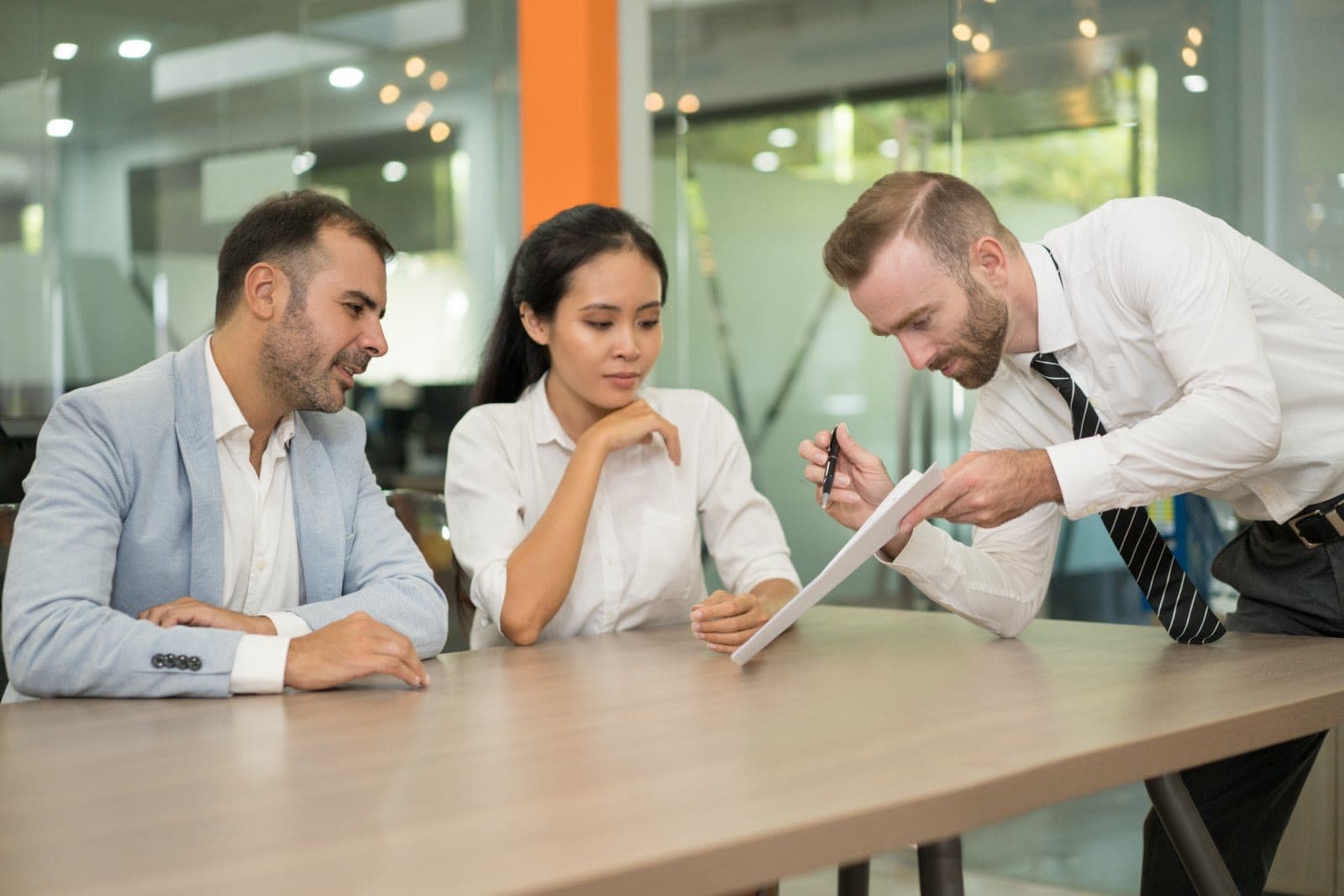 A team reading through a printed document together at a table